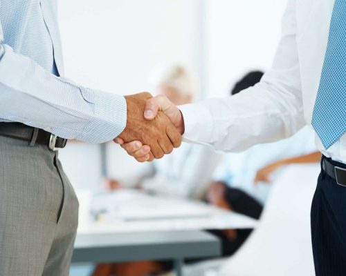 Two business man shaking their hands in office - Corporate deal
